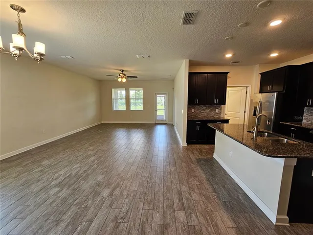 a view of a kitchen with a sink wooden floor and a window
