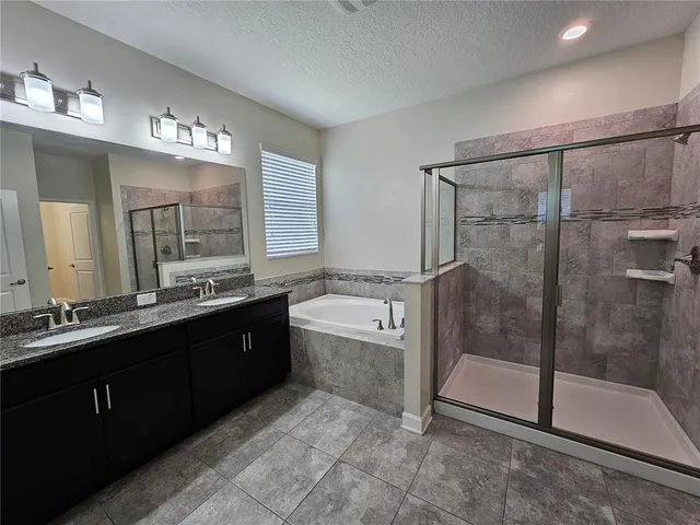 a spacious bathroom with a shower sink and mirror