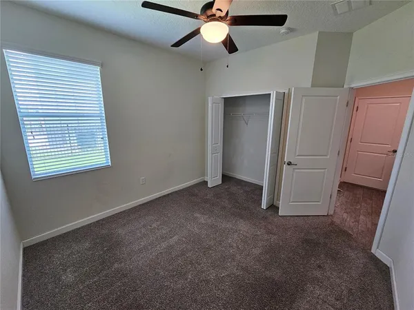 a view of empty room with ceiling fan and window