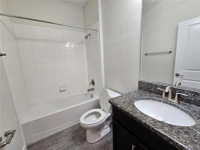 a bathroom with a granite countertop sink toilet and shower