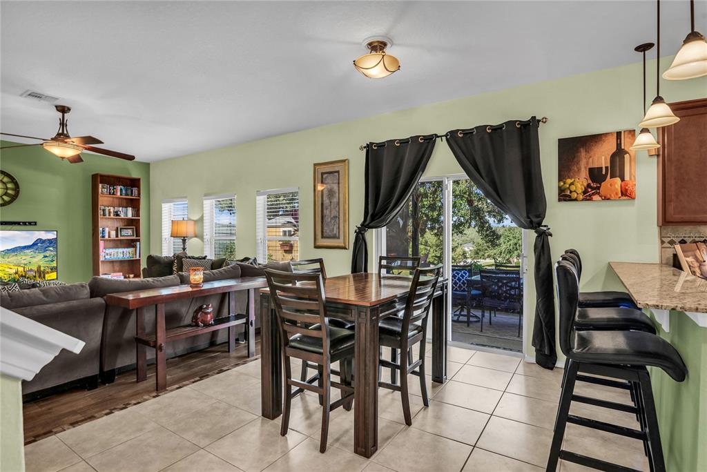 2962 Inca Avenue Clermont, FL 34715 - Photo 15 of 55 a view of a dining room and livingroom with furniture wooden floor a rug a painting and a chandelier