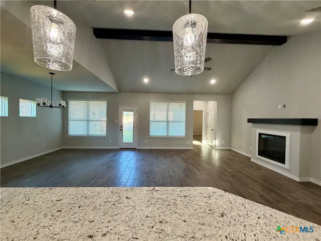 a view of a room with wooden floor and chandelier