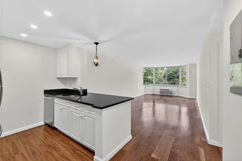 a kitchen with granite countertop a sink and wooden floor