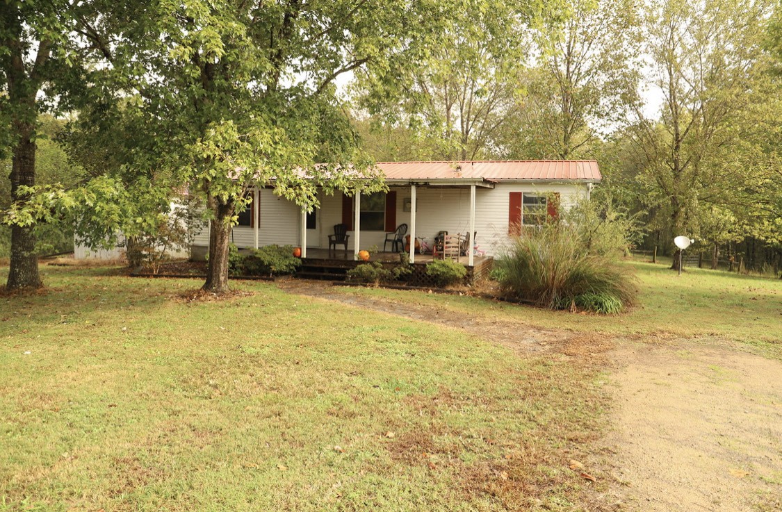 913 Maddox Road Centerville, TN 37033 - Photo 1 of 20 a front view of a house with a garden