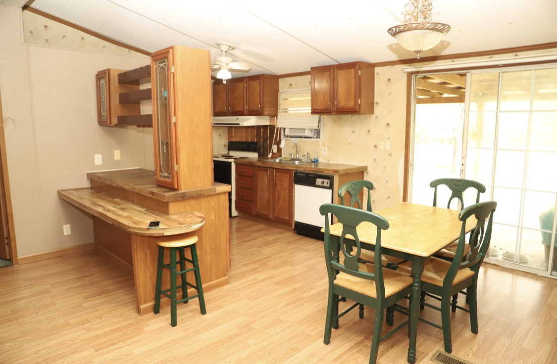 913 Maddox Road Centerville, TN 37033 - Photo 3 of 20 a kitchen with stainless steel appliances kitchen island granite countertop a table chairs and a refrigerator