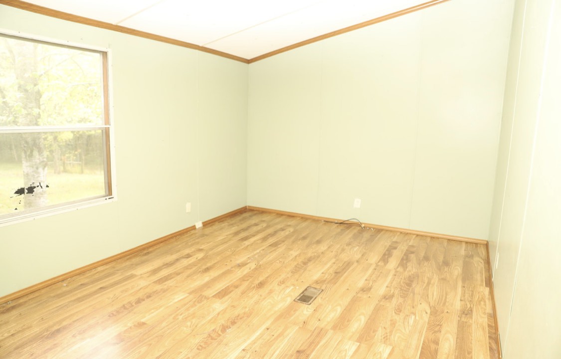 913 Maddox Road Centerville, TN 37033 - Photo 7 of 20 a view of a big room with wooden floor and a window