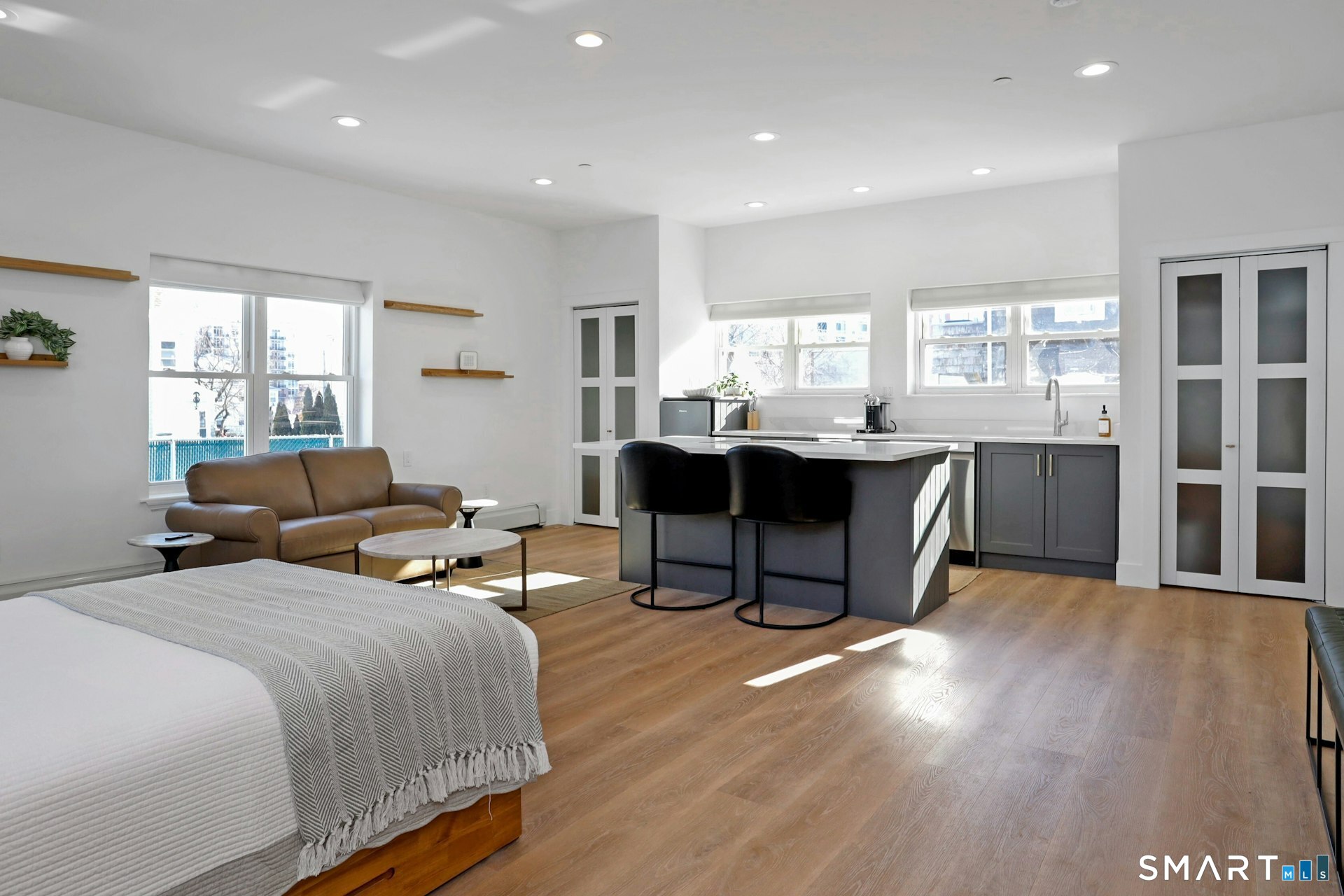 225 Washington Boulevard Stamford, CT 06902 - Photo 13 of 35 a living room with furniture a large window and wooden floor