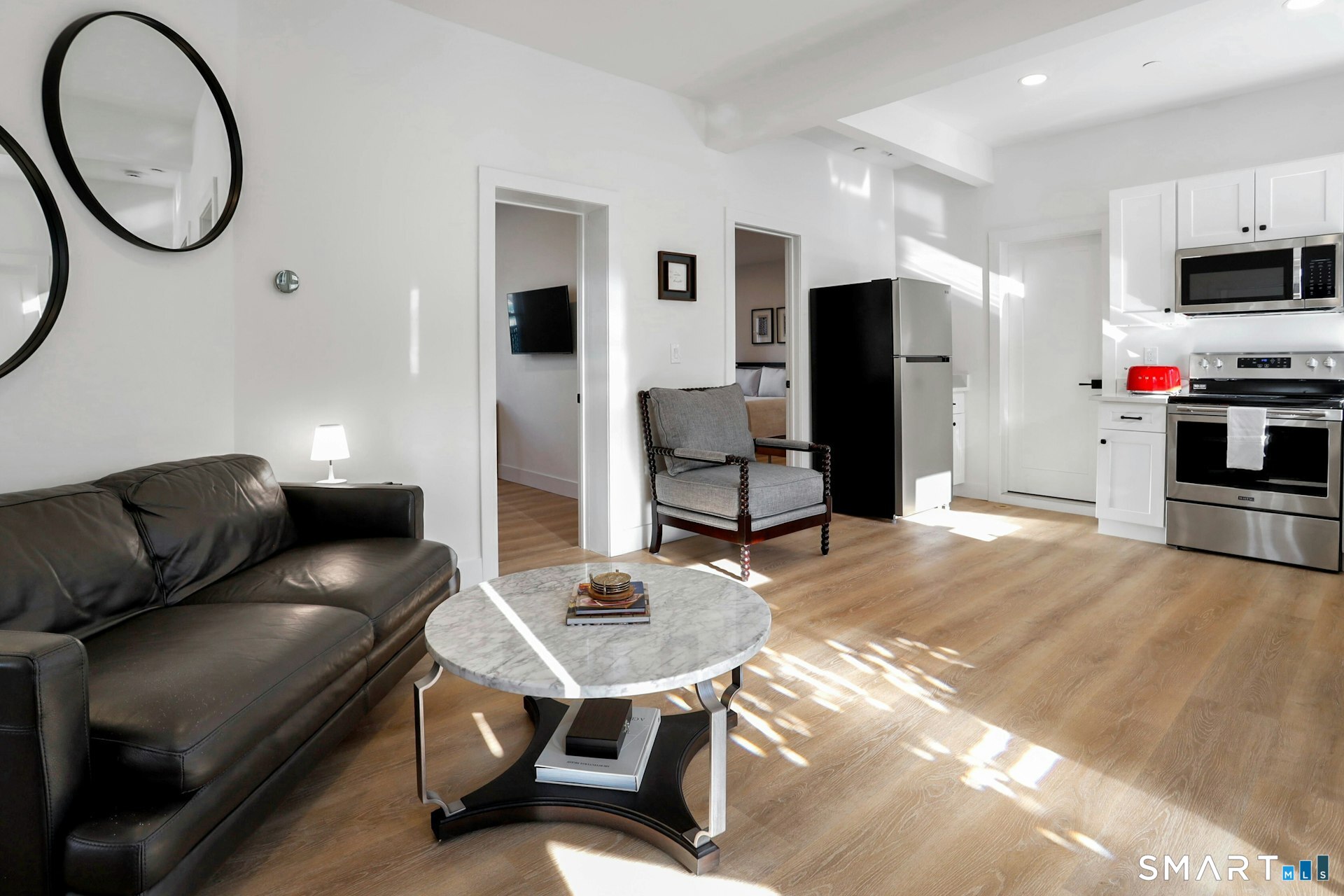 225 Washington Boulevard Stamford, CT 06902 - Photo 2 of 35 a living room with furniture a mirror and a flat screen tv