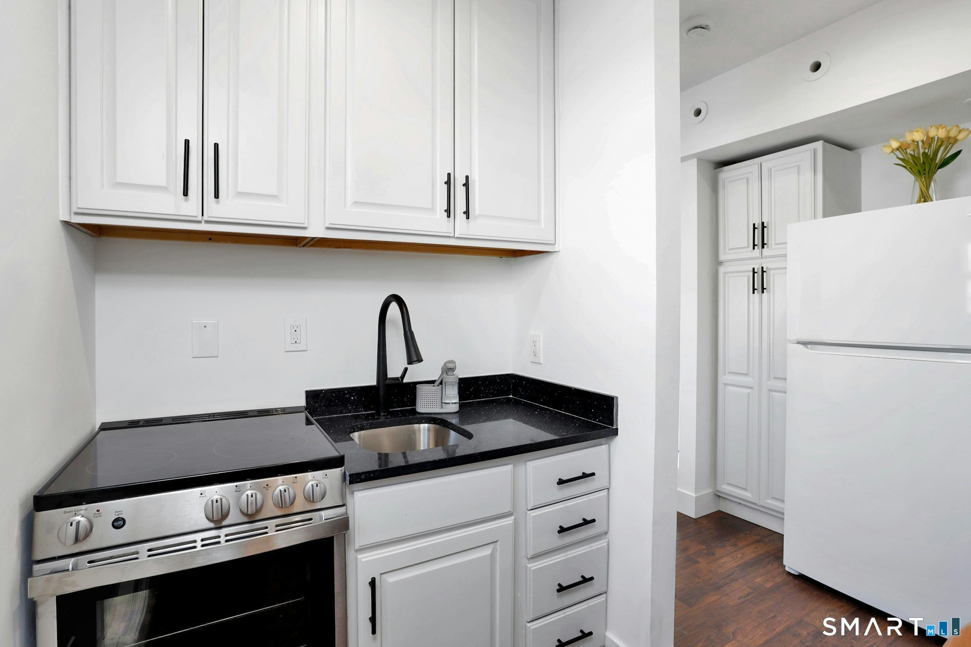 225 Washington Boulevard Stamford, CT 06902 - Photo 27 of 35 a kitchen with granite countertop white cabinets and white appliances