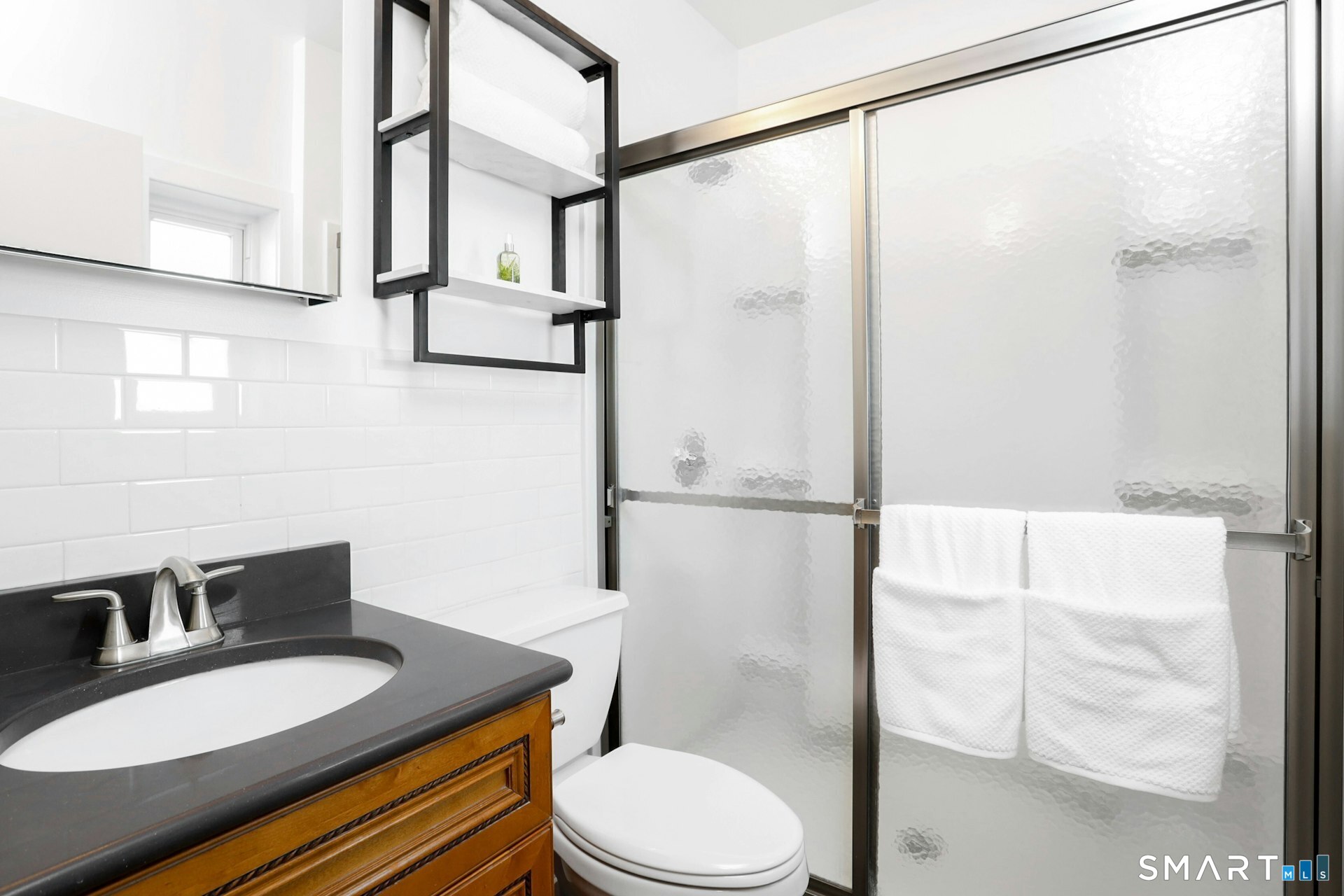 225 Washington Boulevard Stamford, CT 06902 - Photo 29 of 35 a bathroom with a granite countertop sink toilet a mirror and shower