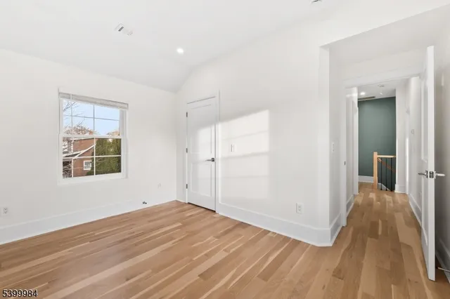 a kitchen with stainless steel appliances a refrigerator a stove a sink dishwasher and white cabinets with wooden floor