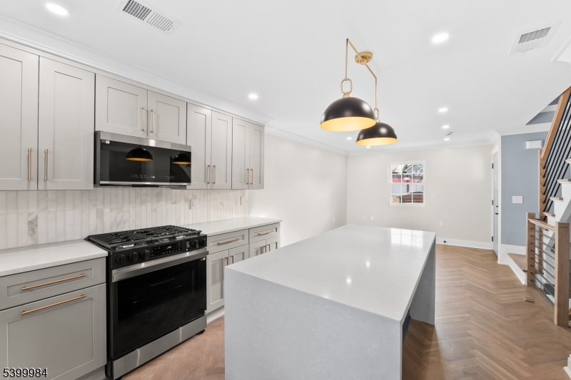 1453 Morris Avenue Union, NJ 07083 - Photo 25 of 48 a kitchen with stainless steel appliances a stove a microwave a sink a stove and cabinets