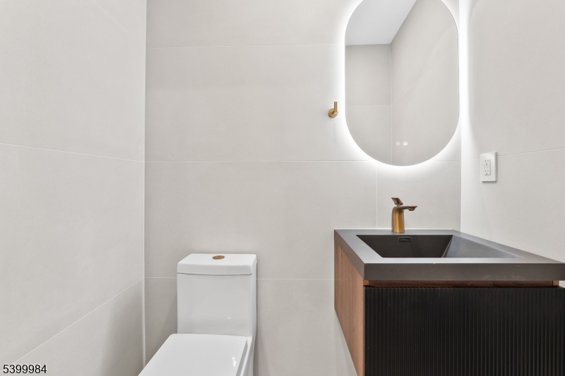 1453 Morris Avenue Union, NJ 07083 - Photo 26 of 48 a bathroom with a sink a toilet and a mirror