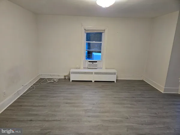 a white room with wooden floor and white walls