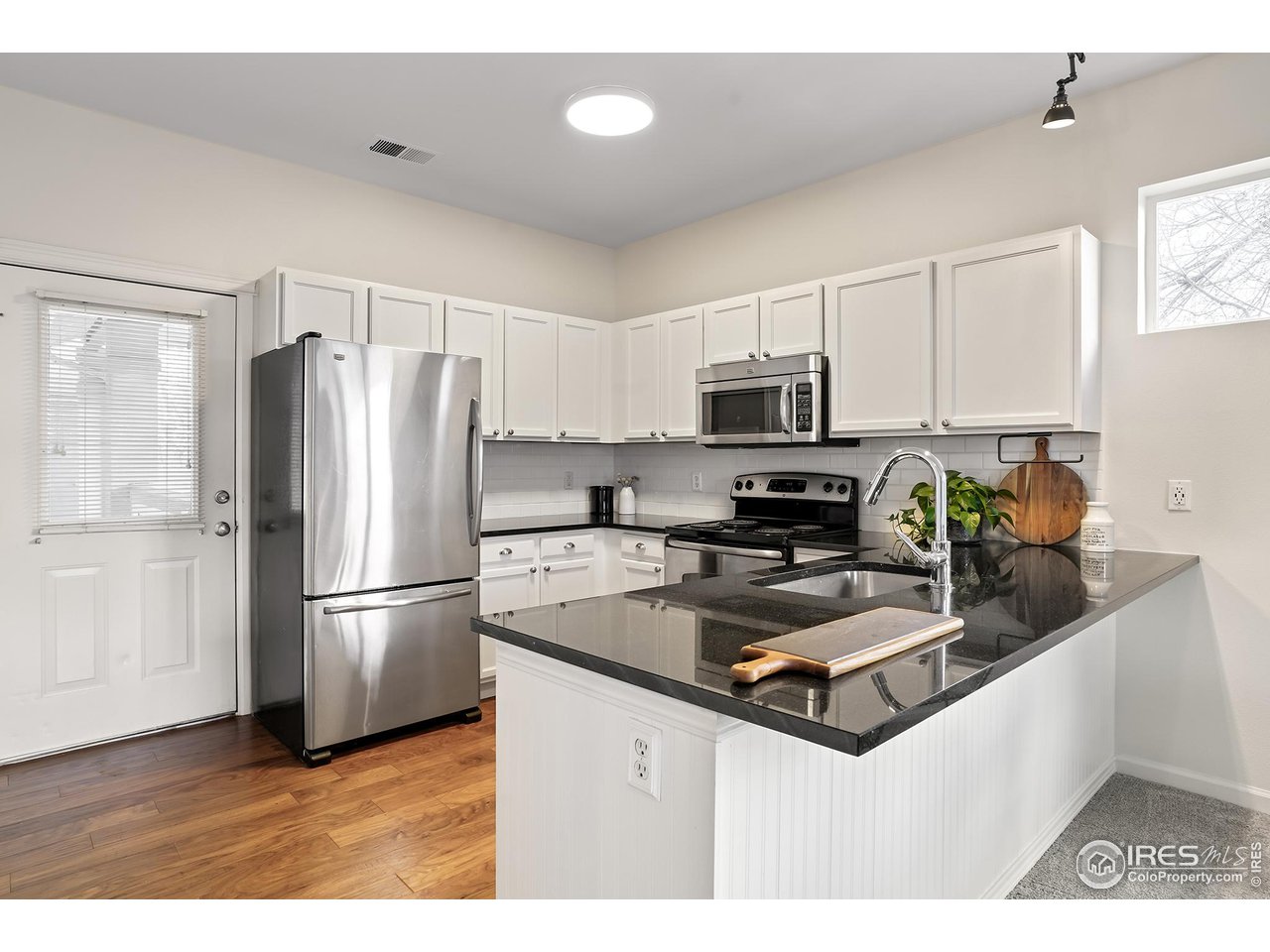 2625 Tabriz Place, Unit 21 Boulder, CO 80304 - Photo 7 of 24 a kitchen with granite countertop a refrigerator a sink a stove a microwave and wooden floor