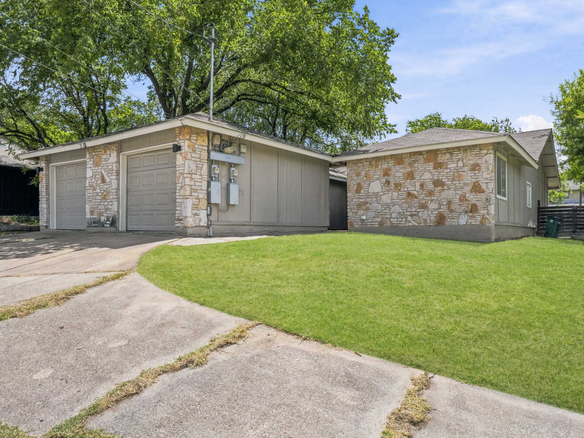 2401 Burleson Road Austin, TX 78741 - Photo 2 of 25 Stone veneer accents and an attached garage enhance this property's curb appeal.