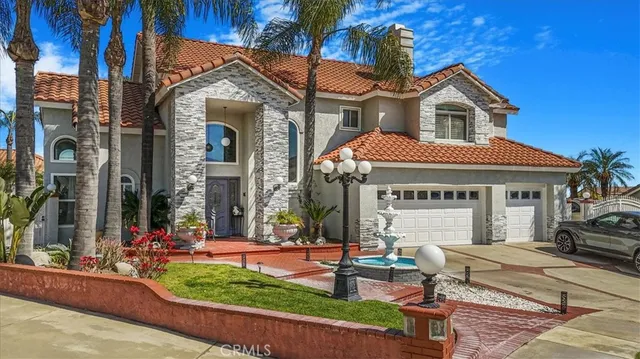 a front view of a house with garden and chairs