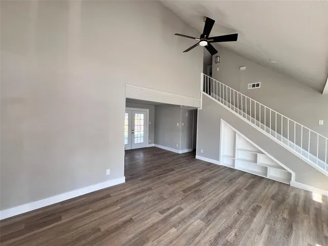 a view of an empty room with a window and wooden floor