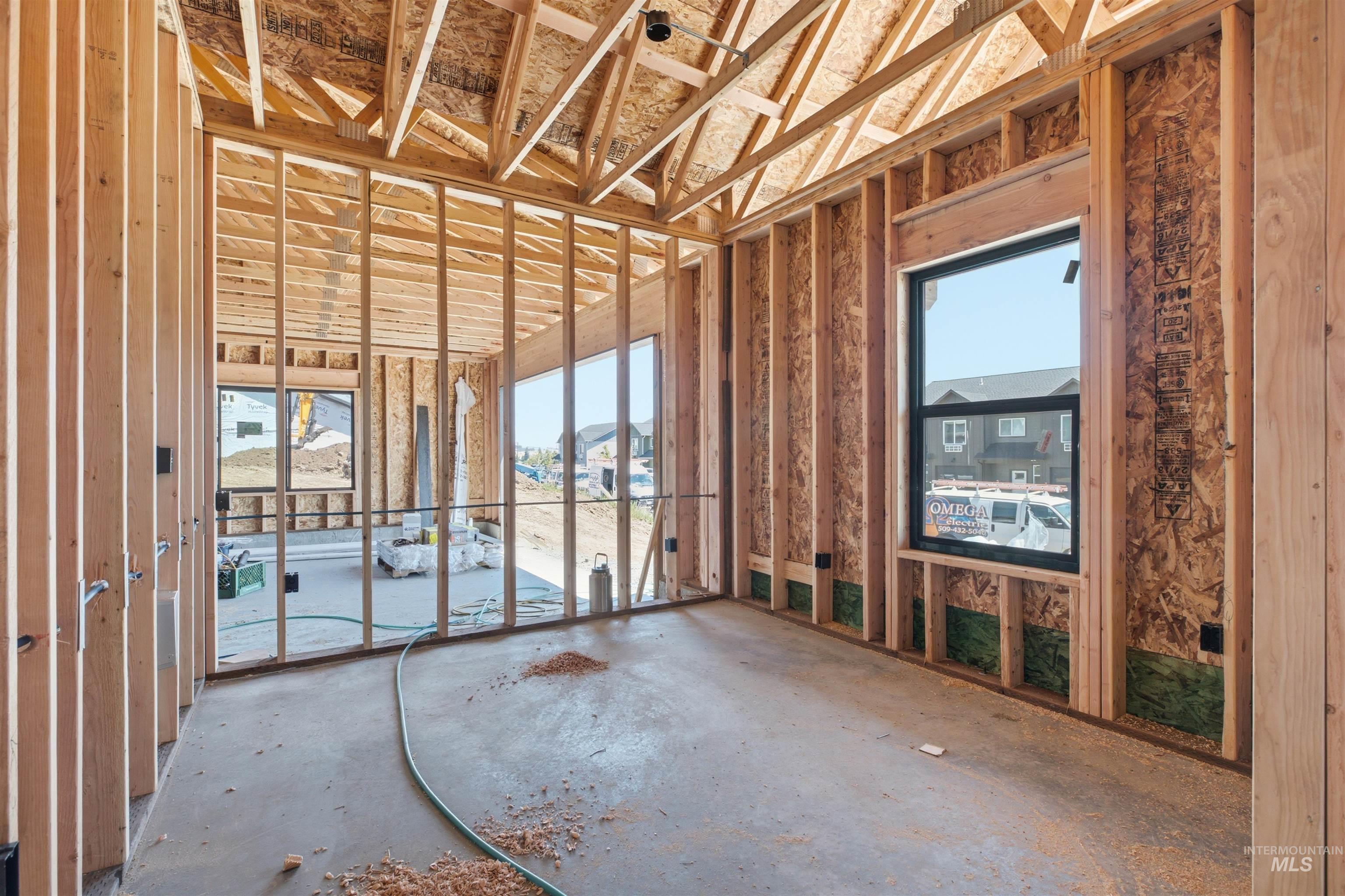 2824 Cyprus Court Moscow, ID 83843 - Photo 8 of 20 Unfinished interior framing with exposed wood studs, concrete slab flooring, and a vaulted ceiling with visible trusses