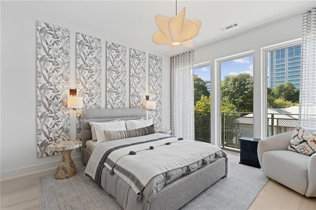 775 Juniper Street Northeast, Unit 227 Atlanta, GA 30308 - Photo 13 of 42 a bedroom with a large bed and a chandelier