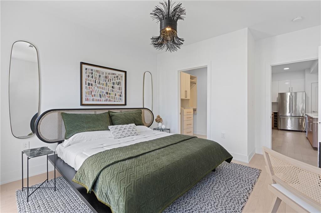 775 Juniper Street Northeast, Unit 227 Atlanta, GA 30308 - Photo 10 of 42 a bedroom with a bed a mirror and paintings on the wall