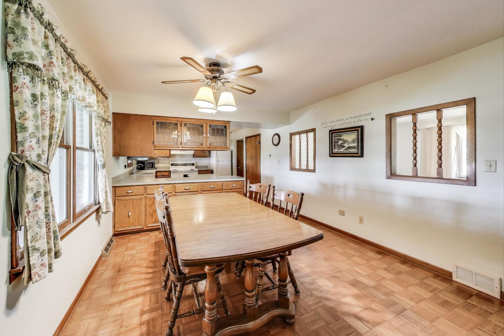 7008 West Kennedy Road Peotone, IL 60468 - Photo 11 of 41 a dining room with stainless steel appliances kitchen island granite countertop a refrigerator a stove a microwave oven with a dining table and chairs with wooden floor