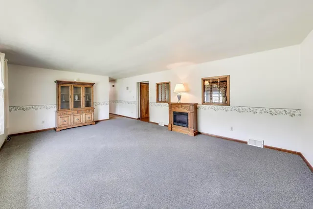 an empty room with a fireplace and cabinet