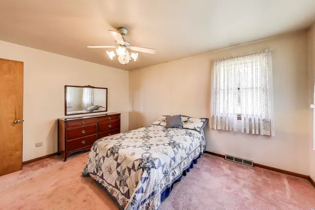 a bedroom with a bed and a dresser in it