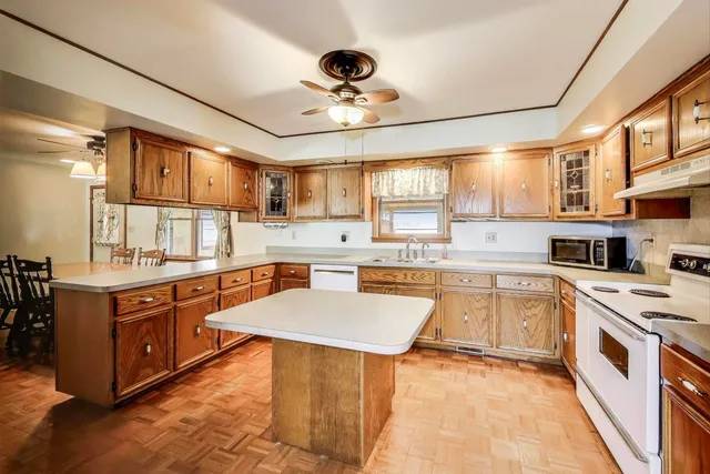 a kitchen with stainless steel appliances granite countertop a sink dishwasher stove and white cabinets