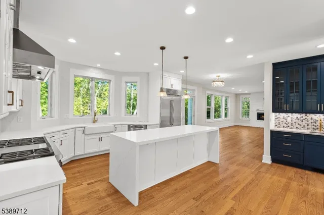 a large kitchen with stainless steel appliances granite countertop a stove a sink and a refrigerator