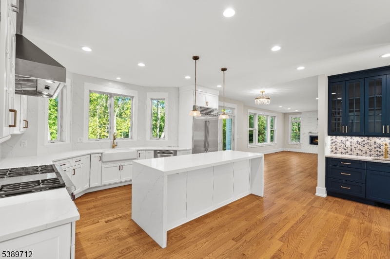 91 Woodland Road Madison, NJ 07940 - Photo 11 of 49 a large kitchen with stainless steel appliances a large counter top a stove a sink and a refrigerator