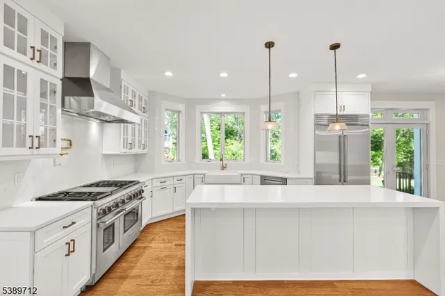 a large kitchen with stainless steel appliances granite countertop a stove and a refrigerator