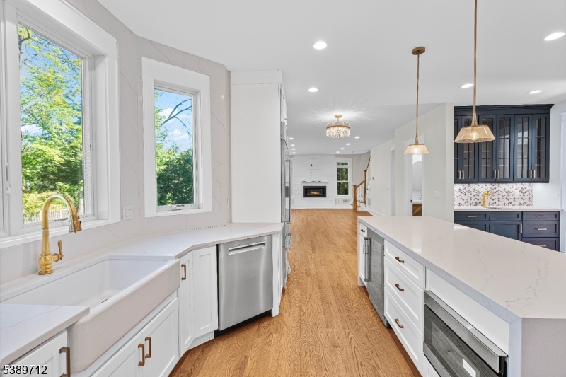 91 Woodland Road Madison, NJ 07940 - Photo 15 of 49 a large white kitchen with lots of counter space wooden floor and stainless steel appliances