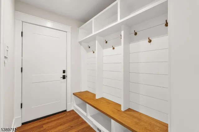 a view of staircase with wooden floor and white walls