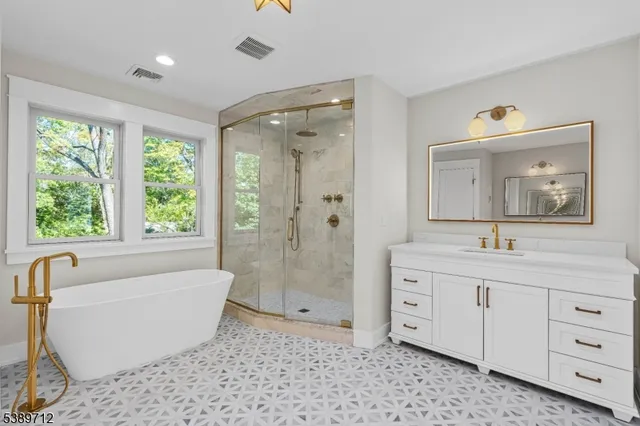 a spacious bathroom with a bathtub sink and mirror