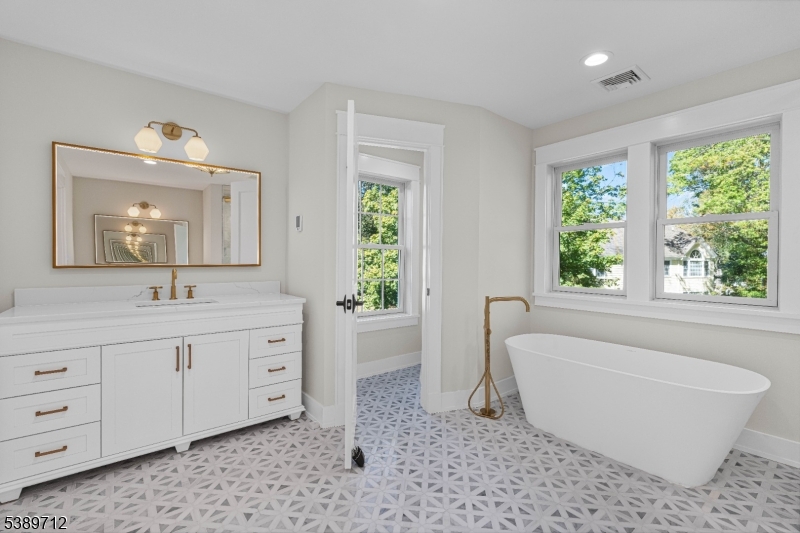 91 Woodland Road Madison, NJ 07940 - Photo 36 of 49 a spacious bathroom with a bathtub sink and mirror