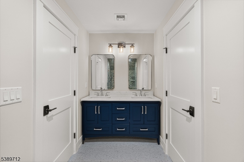 91 Woodland Road Madison, NJ 07940 - Photo 38 of 49 a bathroom with a double vanity sink and mirror with shower