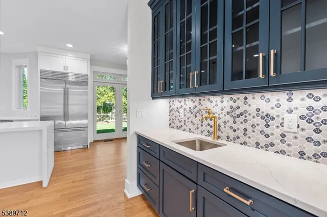 a large white kitchen with granite countertop a stove and a sink