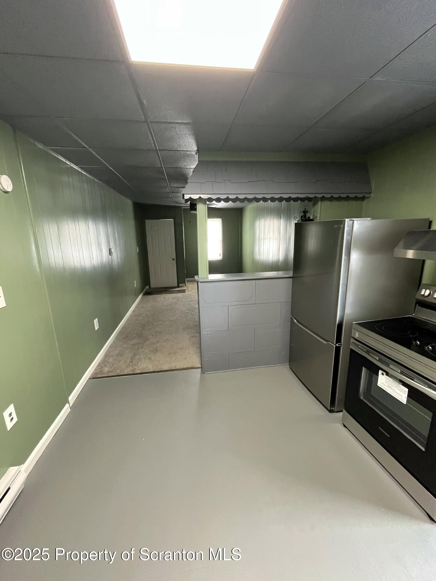 258 Main Street, Unit 1 Dupont, PA 18641 - Photo 3 of 7 a view of a refrigerator in kitchen and windows