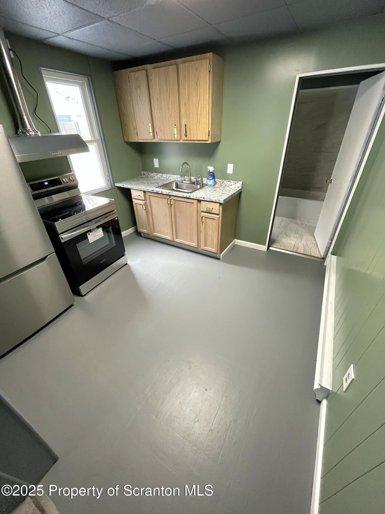 258 Main Street, Unit 1 Dupont, PA 18641 - Photo 5 of 7 a kitchen with a sink and a stove top oven