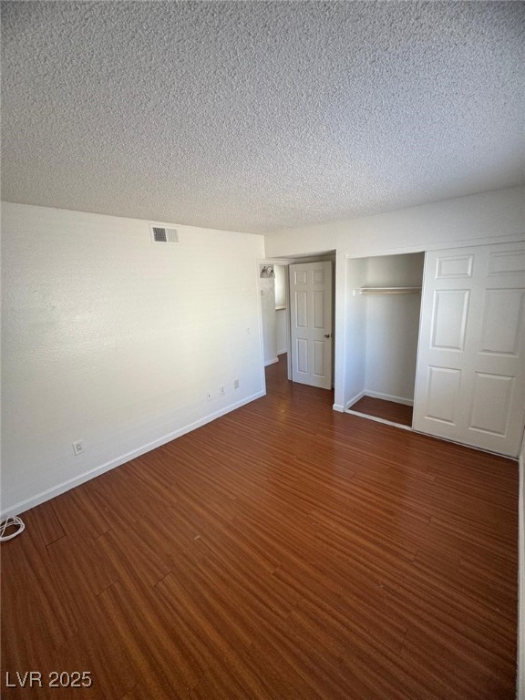 2732 Alicialynn Way, Unit A Las Vegas, NV 89121 - Photo 10 of 14 Unfurnished bedroom with dark wood finished floors, baseboards, and a textured ceiling