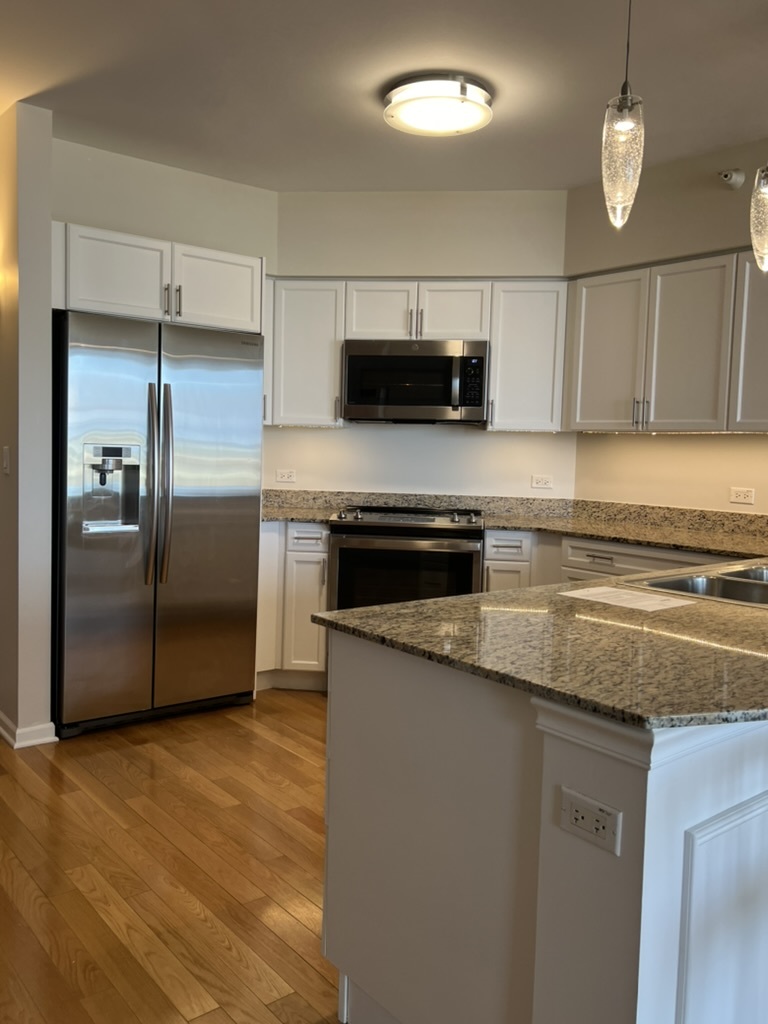 807 Davis Street, Unit 1308 Evanston, IL 60201 - Photo 5 of 16 a kitchen with stainless steel appliances granite countertop a refrigerator a sink and a stove
