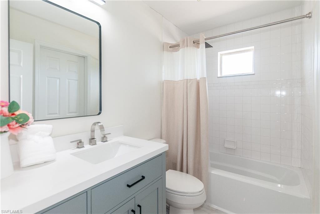 1060 Cooper Drive Naples, FL 34103 - Photo 15 of 24 Bathroom featuring vanity and shower / bath combo with shower curtain