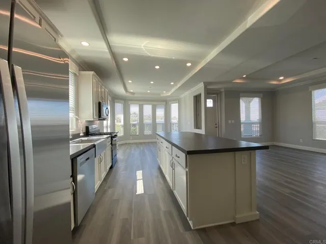 a large kitchen with stainless steel appliances lots of counter space and wooden floor