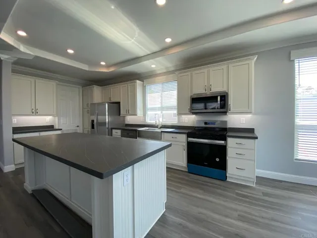 a kitchen with stainless steel appliances granite countertop a sink stove microwave and cabinets