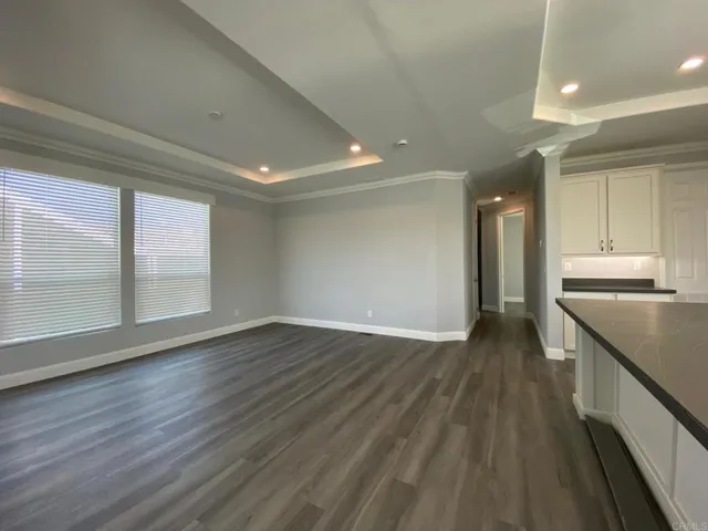 a view of a kitchen with wooden floor and a window