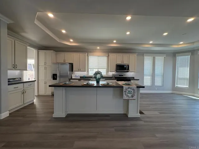 a kitchen with stainless steel appliances granite countertop a refrigerator stove a sink and a microwave