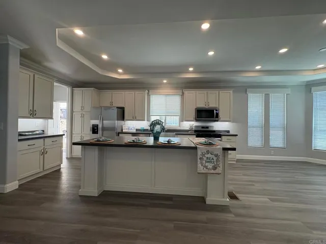 a kitchen with stainless steel appliances wooden floors and view living room
