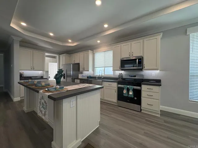 a kitchen with kitchen island granite countertop stainless steel appliances and sink