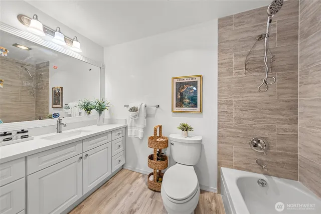 a bathroom with a toilet a sink a tub and mirror